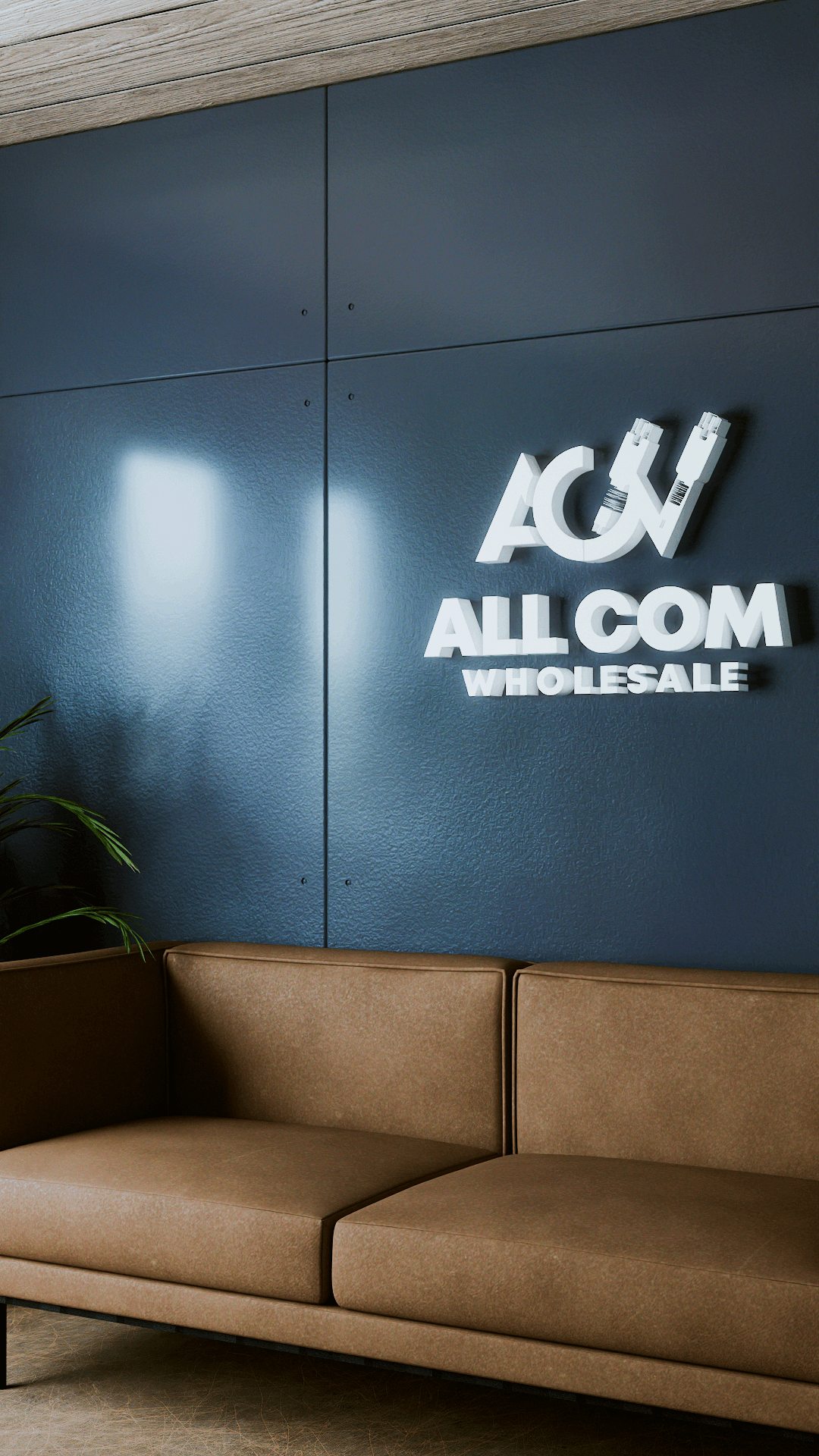 White 3D All Com Wholesale logo on blue wall above a brown leather sofa.